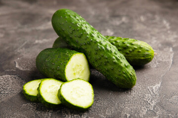 Fresh organic cucumbers against black marble background.Cucumber slices. Salad ingredient. Fresh vegetables. Vegan food. Healthy food. Fresh organic vegetables.