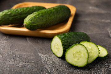 Fresh organic cucumbers against black marble background.Cucumber slices. Salad ingredient. Fresh vegetables. Vegan food. Healthy food. Fresh organic vegetables.