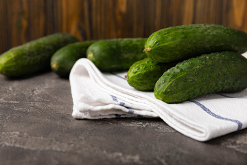 Fresh cucumbers on a white black texture background. Vegetarian organic vegetables.Ingredient for salad. Healthy food.Copy space.Place for text