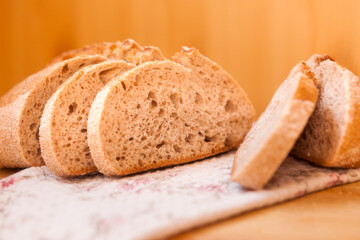 Fresh backed bread with slices on the table, still life with wheat food