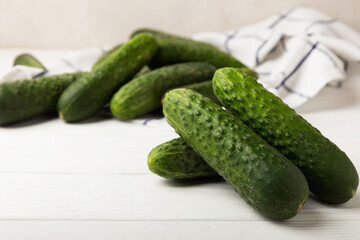 Fresh cucumbers on white texture wood. Vegetarian organic vegetables.Ingredient for salad. Healthy food.Copy space.Place for text
