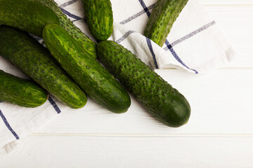 Fresh cucumbers on white texture wood. Vegetarian organic vegetables.Ingredient for salad. Healthy food.Copy space.Place for text