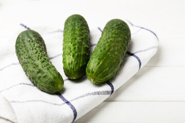 Fresh cucumbers on white texture wood. Vegetarian organic vegetables.Ingredient for salad. Healthy food.Copy space.Place for text