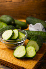 Fresh organic cucumbers on a brown wooden table.Cucumber slices. Salad ingredient. Fresh vegetables. Vegan food. Healthy food. Fresh organic vegetables.