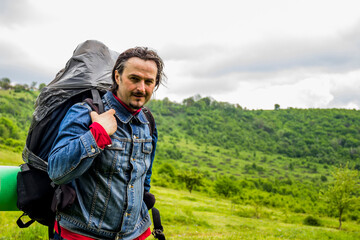 a tourist man with big backpack in the forest