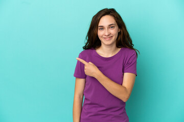 Young caucasian woman isolated on blue background pointing to the side to present a product