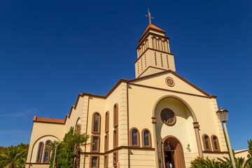 Fototapeta na wymiar Vista lateral da Paróquia São Francisco de Assis - Diocese de Anápolis em Goiás em um dia claro com o céu azul ao fundo.