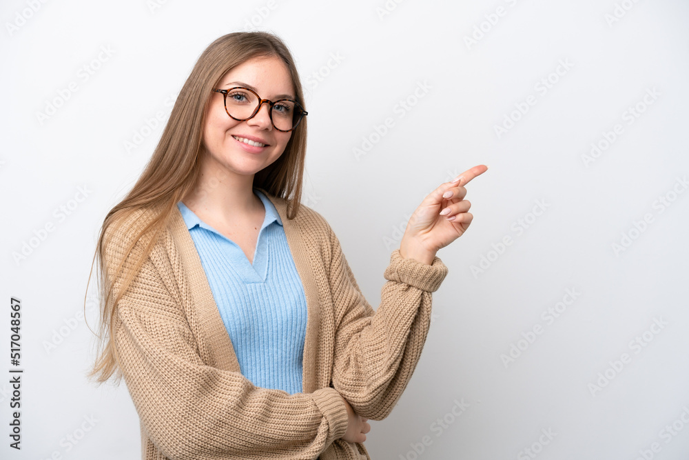 Wall mural young lithuanian woman isolated on white background pointing finger to the side