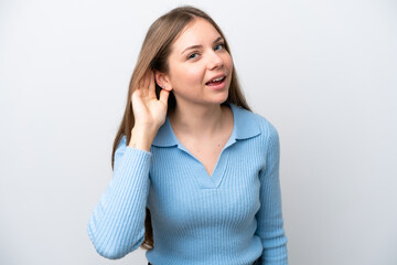 Young Lithuanian woman isolated on white background listening to something by putting hand on the ear