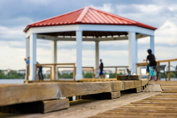 People relax under gazebo on lake