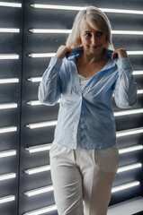 Fototapeta premium a woman in a blue shirt near a wall with backlight