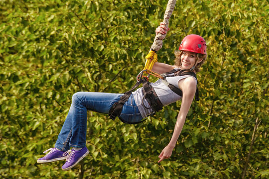 Young Woman After The Bungee Jump Against Green Foliage