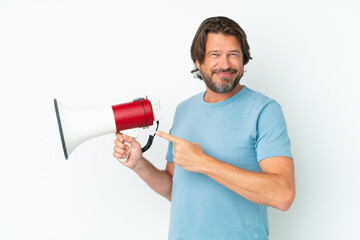 Senior dutch man isolated on white background holding a megaphone and pointing side