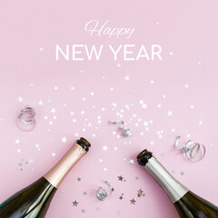Inscription Happy New Year and two bottles of classic champagne on pink background decorated with...