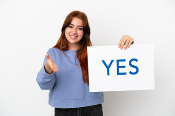 Young redhead woman isolated on white background holding a placard with text YES making a deal