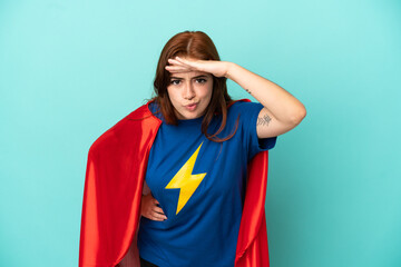 Young caucasian woman isolated on white background in superhero costume and showing something © luismolinero
