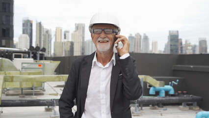 An old elderly engineer man or worker, people working in industry factory, using a mobile phone...