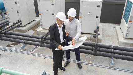 Engineer men or worker team, people working in industry factory. Chiller tower on rooftop building....