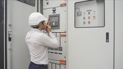 An engineer man or worker, people working in electrical room. Power energy motor machinery cabinets with panel in control or server room, operator station network in industry factory. Switchgear