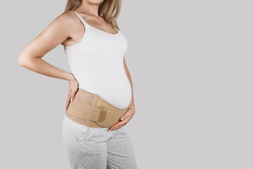 Pregnant woman belly in prenatal pregnancy maternity belt. Orthopedic abdominal support waist,...