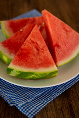 a plate of fresh watermelon with a blue napkin