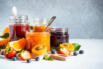 Fototapeta na wymiar Homemade jams, natural preservation in glass jars with ingredients, fresh fruits and berries.