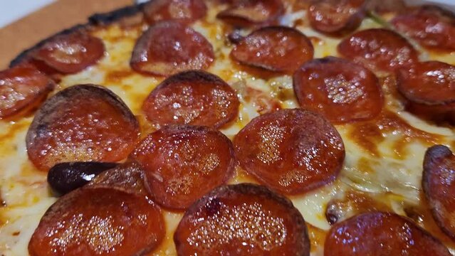 Closeup video of a sizzling pepperoni pizza right out of the oven. Hot and Ready: Fresh Oven-Baked Pizza