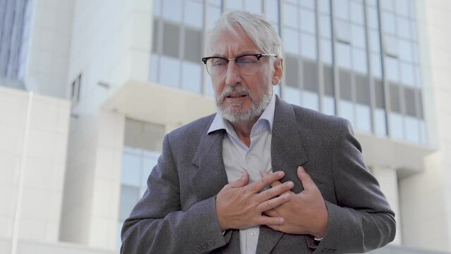 Senior man touching sore chest, feeling pain in chest, heart attack, emergency