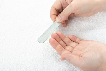 Woman shaping her nails with a nail file.