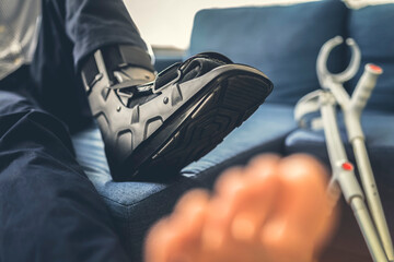 Man with foot brace on the sofa.