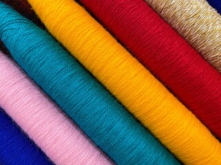 Colorful threads. Yarn. Bobbins with yarn. Fabric. Sewing threads. Skein of thread. Texture of colorful thread in spoolls.