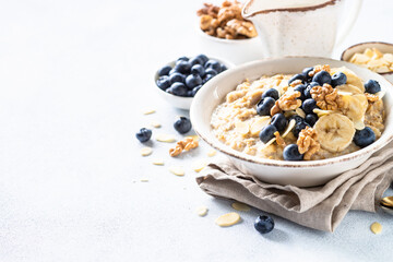 Oatmeal porrige in craft bowl at white background. Healthy breakfast.