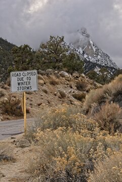 Road closed due to winter storms warning sign on road as storm approaches
