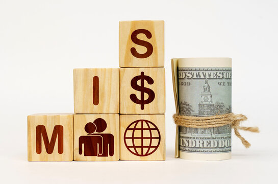 On a white surface, dollars and cubes with images and the inscription - MIS