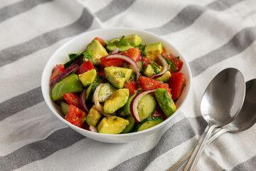 Homemade Organic Cucumber, Tomato and Avocado Salad in a Bowl, low angle view.