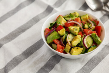 Homemade Organic Cucumber, Tomato and Avocado Salad in a Bowl, low angle view. Space for text.