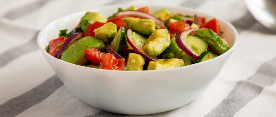 Homemade Organic Cucumber, Tomato and Avocado Salad in a Bowl, side view.