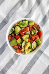 Homemade Organic Cucumber, Tomato and Avocado Salad in a Bowl, top view. Flat lay, overhead, from above.