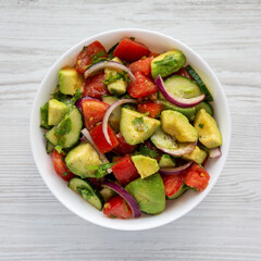 Homemade Organic Cucumber, Tomato and Avocado Salad in a Bowl, top view. Flat lay, overhead, from above.