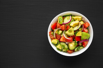 Homemade Organic Cucumber, Tomato and Avocado Salad in a Bowl, top view. Flat lay, overhead, from above.
