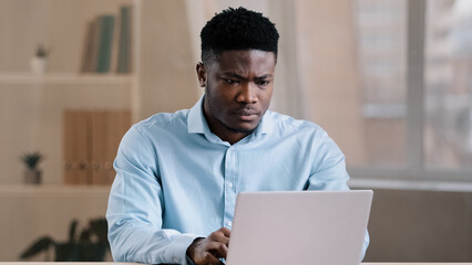 Angry guy annoyed african american man male boss worker dissatisfied has problem with computer system work feels wrath aggression with unsuccessful business deal slow internet read bad news data loss