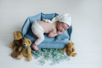 beautiful newborn baby boy sleeping sweetly on his tummy near fragrant flowers