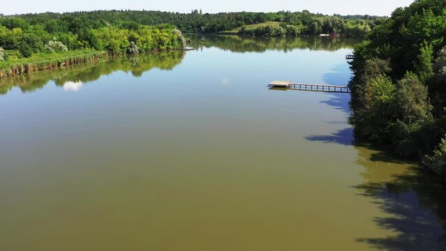 Beautiful carpfishing summer lake with a wood platform. Drone aerial video footage.