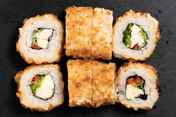 Sushi rolls with tomato and cheese on a black background. Close-up. Japanese food. Top view.Japanese cuisine restaurant, sushi