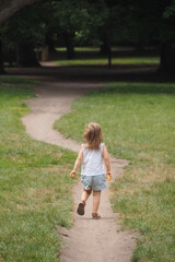 Dziecko biegnie po ścieżce w parku latem