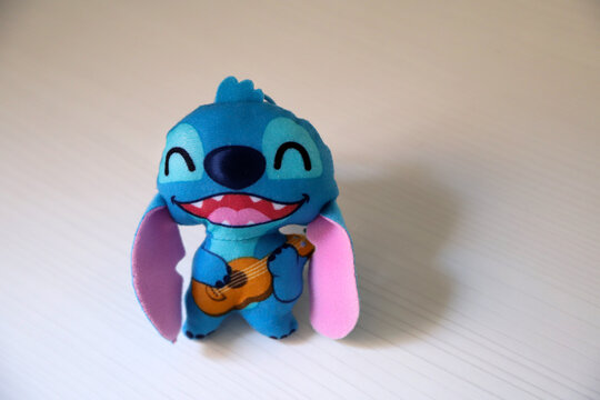 Stitch. Lilo y Stitch. Character from the movie Lilo and Stitch. McDonald's happy meal toy. Experiment 626. Blue creature. Walt Disney character. Stitch playing the Hawaiian ukulele.