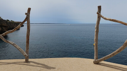 Wooden railings over the precipice. Panoramic sea view. Menorca, Spain