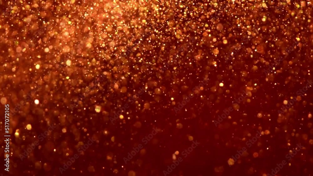 Wall mural falling golden particles in red fluid. gold dust particles and bokeh move slowly in red liquid. abst