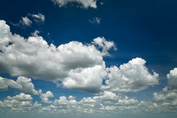 White puffy cumulus clouds on summer blue sky