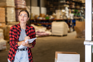 Obraz premium Female manager leads the accounting of materials in a large warehouse